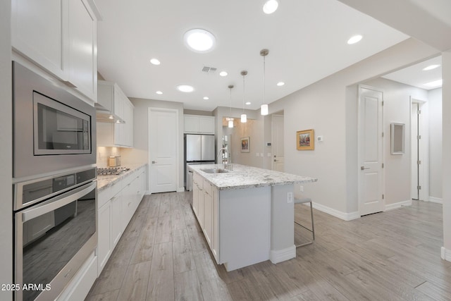 18746 W Rancho Dr, Litchfield Park, AZ 85340 - kitchen featuring light wood-style flooring, appliances with stainless steel finishes, a sink, white cabinetry, and visible vents