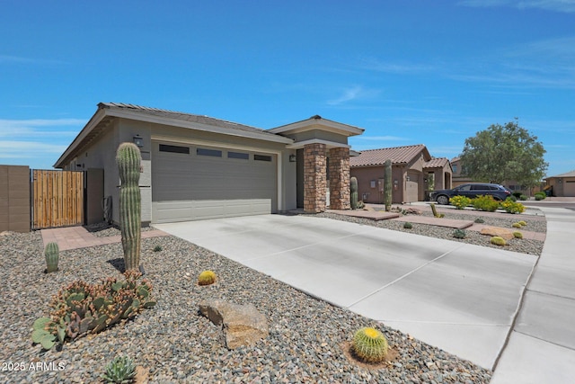 18746 W Rancho Dr, Litchfield Park, AZ 85340 - view of front of home featuring a garage, a gate, driveway, a tiled roof, and stucco siding