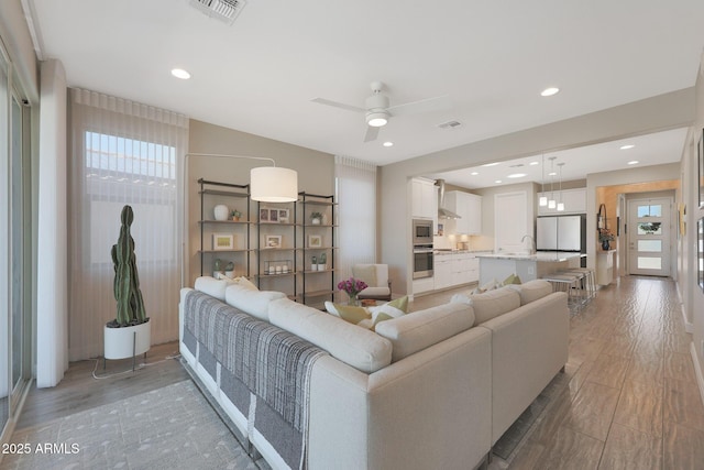 18746 W Rancho Dr, Litchfield Park, AZ 85340 - living area with light wood finished floors, a ceiling fan, visible vents, and a wealth of natural light
