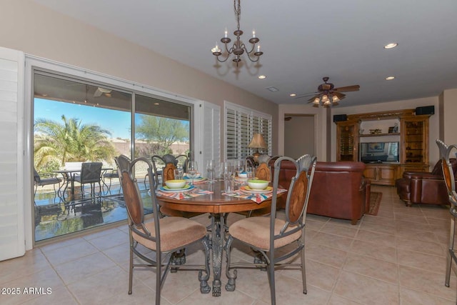 tiled dining area with ceiling fan with notable chandelier