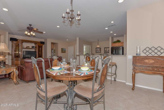 dining room with ceiling fan with notable chandelier and light tile patterned flooring