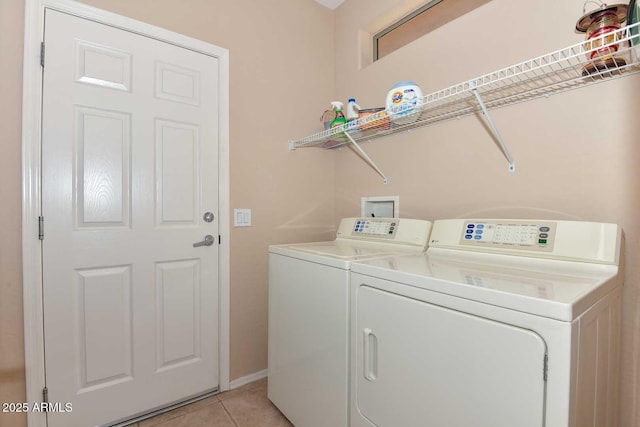 laundry area with independent washer and dryer and light tile patterned floors