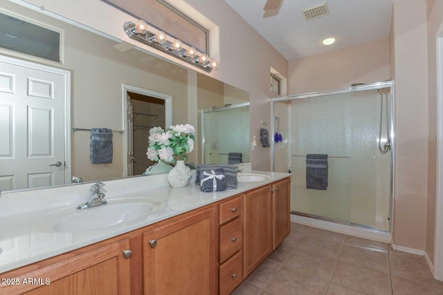 bathroom with tile patterned flooring, vanity, ceiling fan, and an enclosed shower