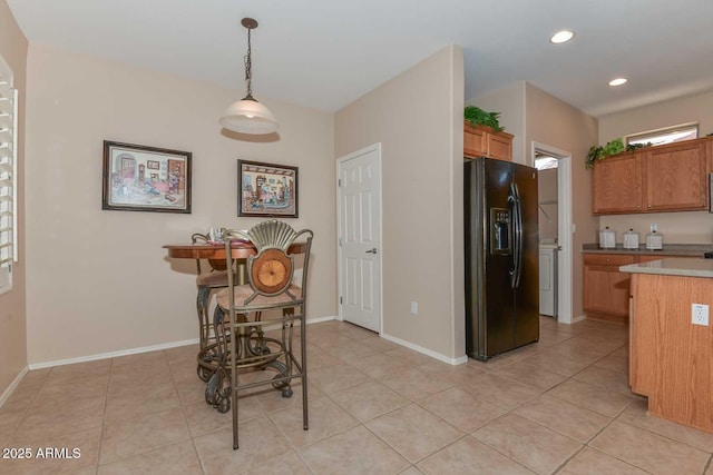 kitchen featuring pendant lighting, light tile patterned floors, and black refrigerator with ice dispenser