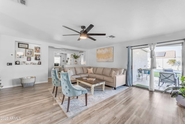 living room with ceiling fan and light wood-type flooring