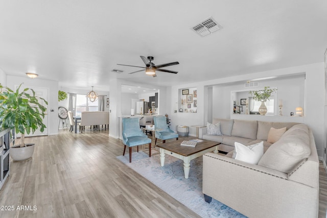 living room featuring ceiling fan and light hardwood / wood-style floors