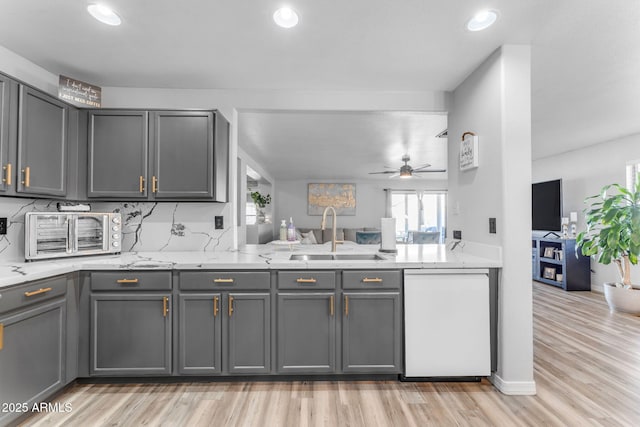 kitchen featuring ceiling fan, sink, dishwasher, and gray cabinets