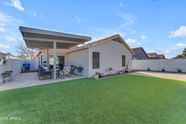 rear view of house with a lawn and a patio