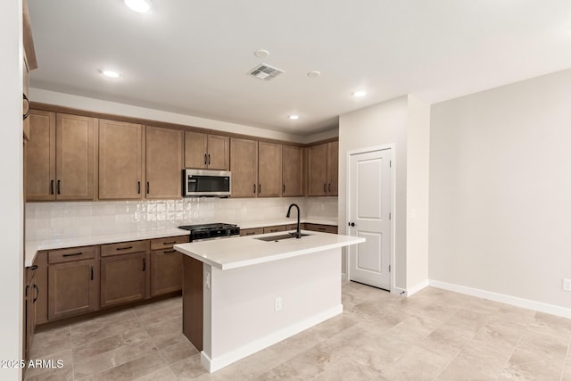 5641 N 205th Ln, Buckeye, AZ 85396 - kitchen with stainless steel microwave, a sink, tasteful backsplash, range with gas cooktop, and light countertops