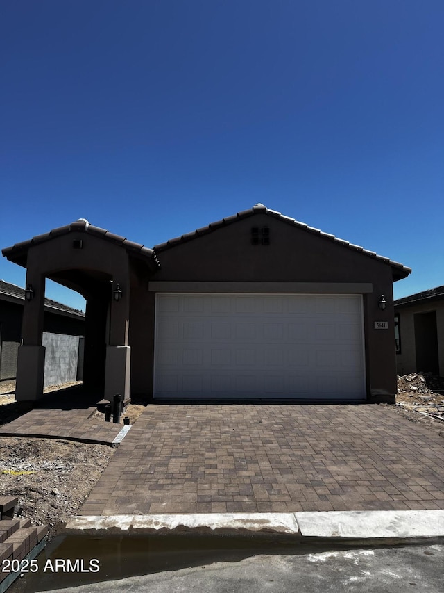 5641 N 205th Ln, Buckeye, AZ 85396 - view of front of property with stucco siding, decorative driveway, a garage, and a tile roof
