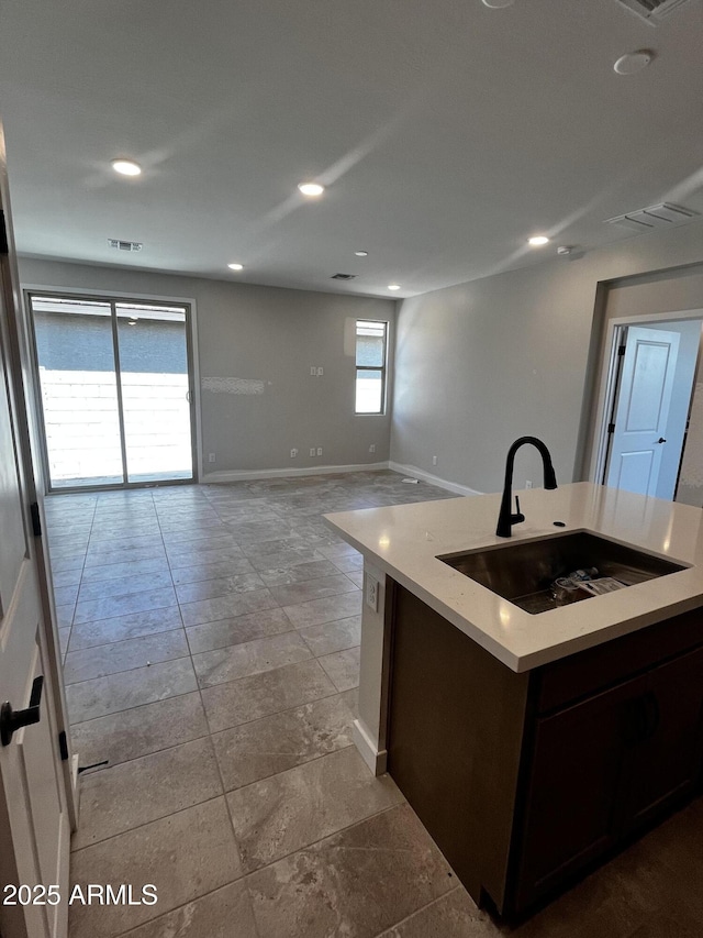 5641 N 205th Ln, Buckeye, AZ 85396 - kitchen featuring a sink, baseboards, light countertops, recessed lighting, and a center island with sink