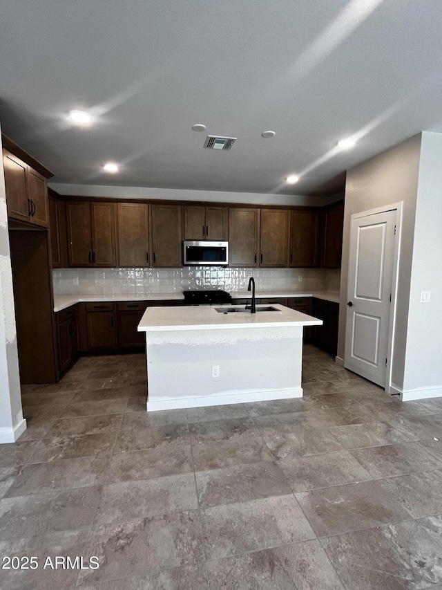 5641 N 205th Ln, Buckeye, AZ 85396 - kitchen featuring stainless steel microwave, a sink, decorative backsplash, baseboards, and light countertops