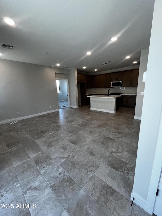 5641 N 205th Ln, Buckeye, AZ 85396 - unfurnished living room featuring a sink, recessed lighting, and baseboards