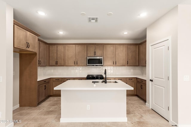 5641 N 205th Ln, Buckeye, AZ 85396 - kitchen featuring stainless steel microwave, a sink, backsplash, a kitchen island with sink, and recessed lighting
