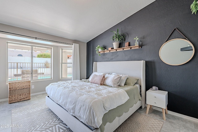 bedroom with lofted ceiling, baseboards, and light tile patterned floors