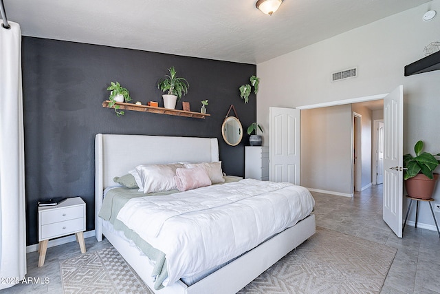 bedroom featuring baseboards and visible vents