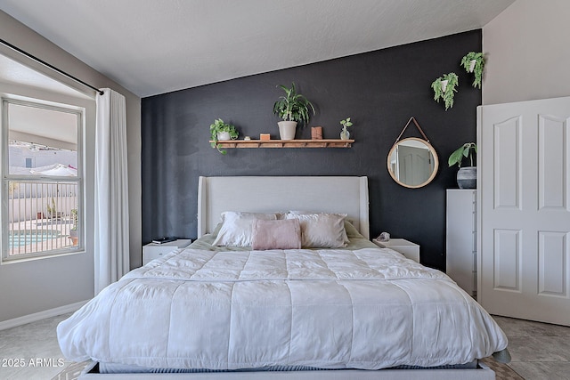 bedroom with vaulted ceiling and baseboards