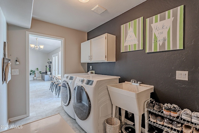 clothes washing area featuring an inviting chandelier, visible vents, washing machine and dryer, baseboards, and cabinet space