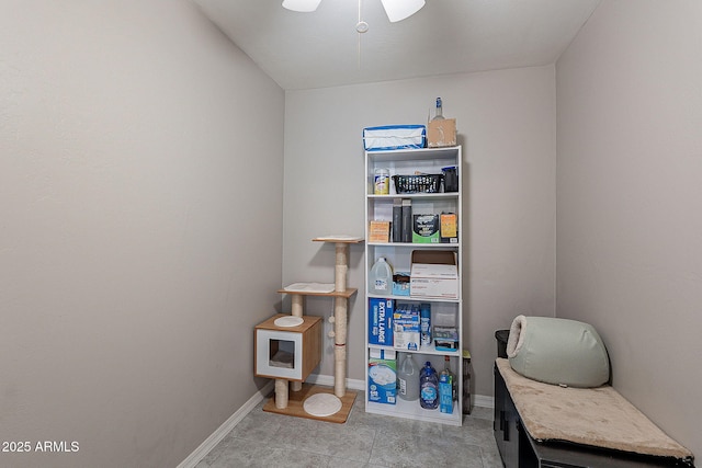 interior space with tile patterned flooring, a ceiling fan, and baseboards