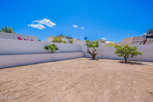 view of yard featuring a fenced backyard and central AC