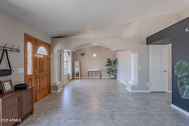 foyer with baseboards, arched walkways, and ornate columns