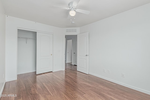 23637 N Desert Dr, Florence, AZ 85132 - unfurnished bedroom with wood finished floors, a closet, baseboards, and a ceiling fan