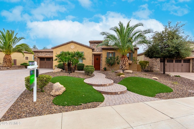 28247 N 128th Dr, Peoria, AZ 85383 - view of front of house with a garage, stone siding, decorative driveway, and stucco siding