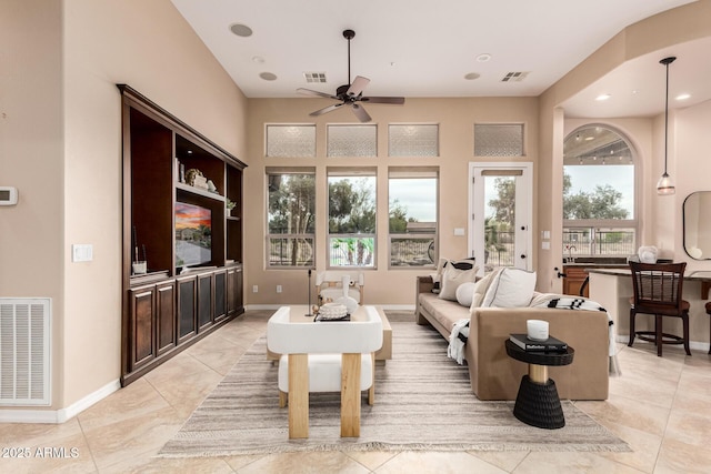 living room featuring baseboards, visible vents, and ceiling fan