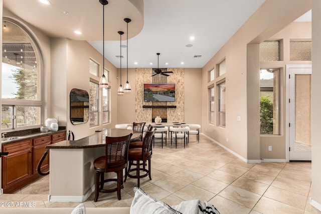 28247 N 128th Dr, Peoria, AZ 85383 - kitchen with a breakfast bar area, brown cabinets, decorative light fixtures, a sink, and recessed lighting