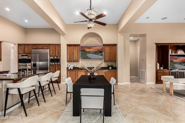 28247 N 128th Dr, Peoria, AZ 85383 - kitchen featuring visible vents, a towering ceiling, a sink, built in appliances, and a kitchen breakfast bar