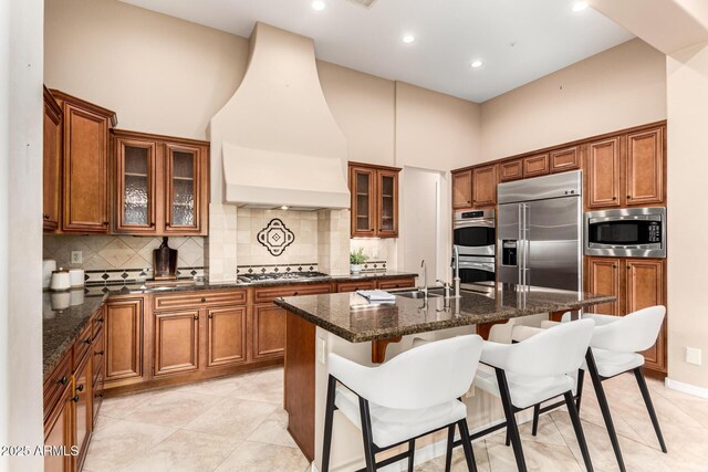 28247 N 128th Dr, Peoria, AZ 85383 - kitchen featuring brown cabinetry, a sink, custom exhaust hood, and built in appliances