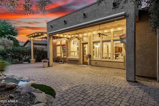 28247 N 128th Dr, Peoria, AZ 85383 - back of property at dusk featuring a pergola and stucco siding