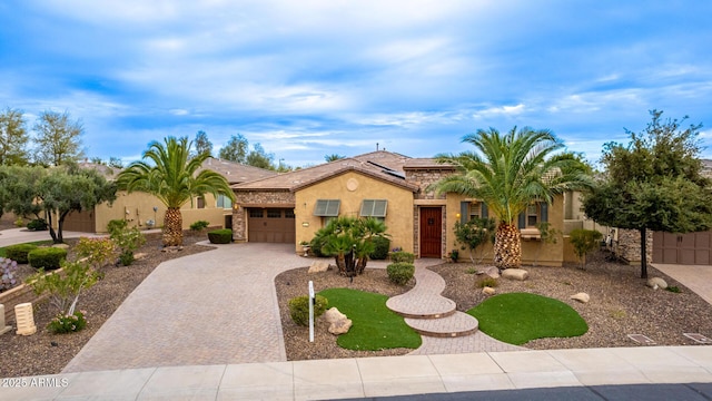 28247 N 128th Dr, Peoria, AZ 85383 - mediterranean / spanish house featuring an attached garage, solar panels, fence, decorative driveway, and stucco siding