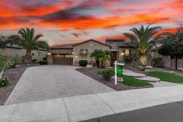 28247 N 128th Dr, Peoria, AZ 85383 - mediterranean / spanish-style home with an attached garage, stone siding, decorative driveway, and stucco siding