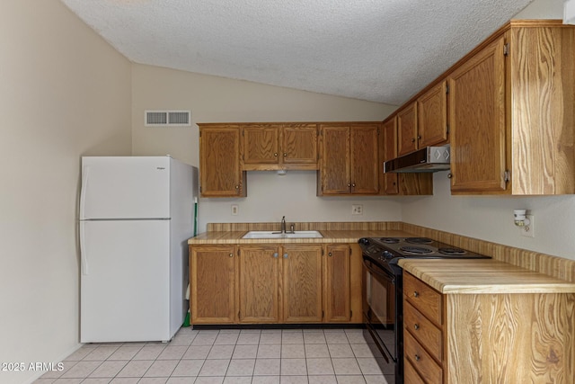 6711 W Osborn Rd Unit 82, Phoenix, AZ 85033 - kitchen featuring freestanding refrigerator, black range with electric cooktop, under cabinet range hood, vaulted ceiling, and light tile patterned floors