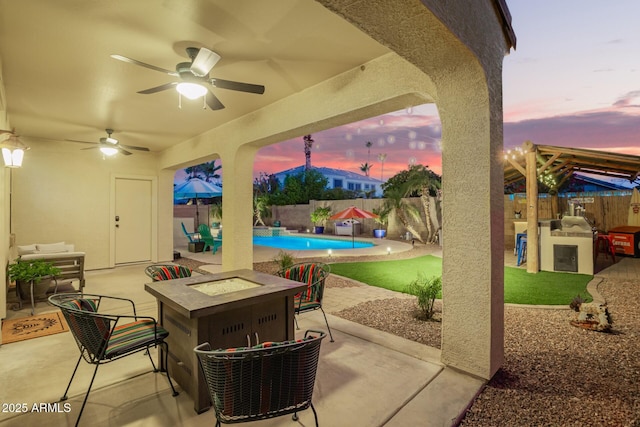 5628 N Rattler Way, Litchfield Park, AZ 85340 - patio terrace at dusk featuring a fenced backyard, a patio, and a fire pit