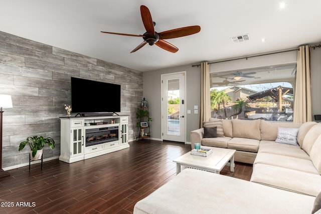 5628 N Rattler Way, Litchfield Park, AZ 85340 - living area featuring ceiling fan, an accent wall, dark wood finished floors, baseboards, and a fireplace