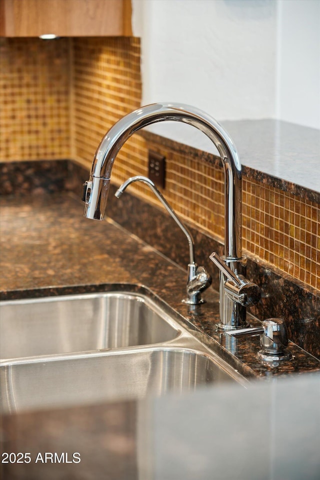 room details featuring decorative backsplash and a sink