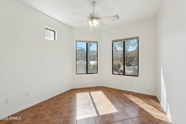 tiled spare room with baseboards and a ceiling fan