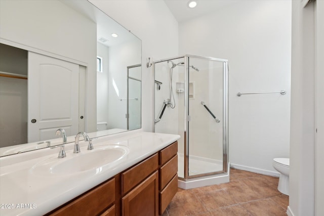 bathroom with vanity, tile patterned floors, toilet, and a stall shower