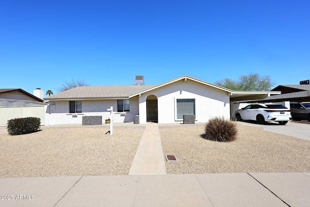 ranch-style home featuring driveway, a carport, and brick siding