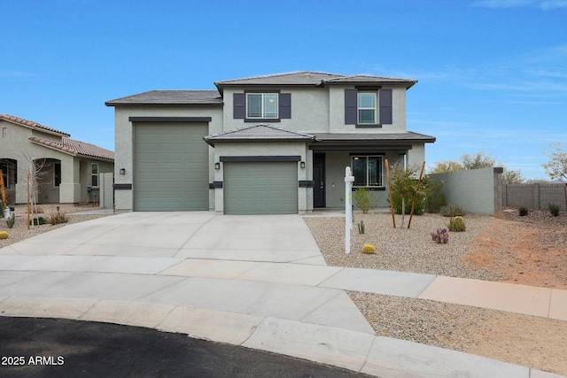 view of front of house featuring driveway, an attached garage, fence, and stucco siding