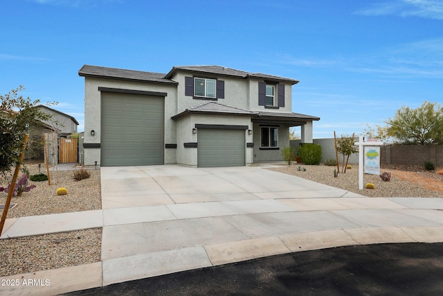 view of front of property with concrete driveway, fence, and stucco siding