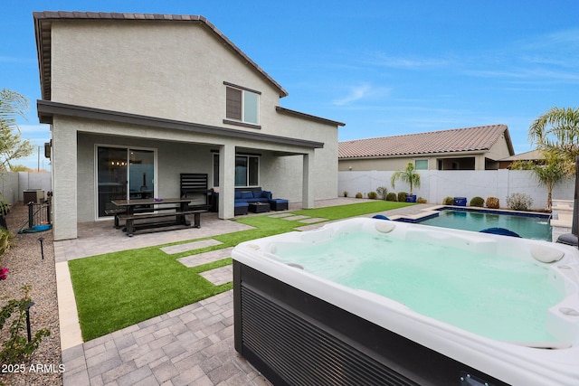 rear view of house with an outdoor living space, a hot tub, cooling unit, and a patio area