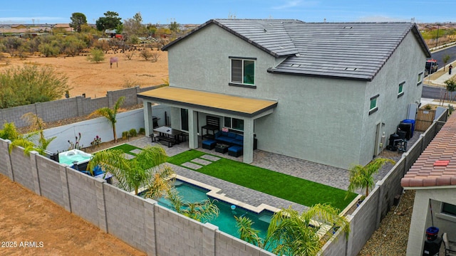 back of house with an outdoor living space, a fenced in pool, and a patio