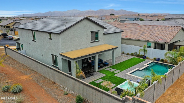 back of property featuring a mountain view, a tile roof, a fenced backyard, and a residential view