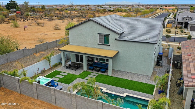 rear view of house featuring a patio, cooling unit, a fenced backyard, a residential view, and stucco siding