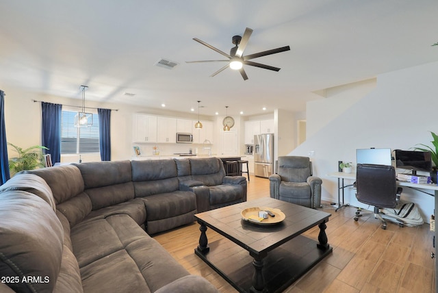 living room with ceiling fan and light hardwood / wood-style floors