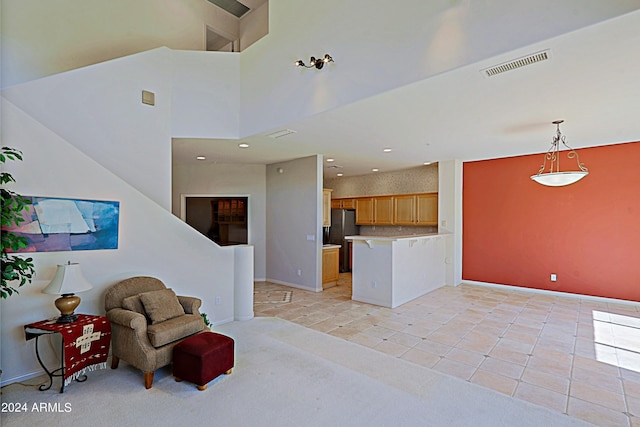 living area with light tile patterned flooring and a towering ceiling