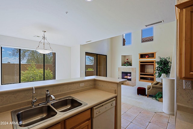 kitchen with light tile patterned flooring, a fireplace, dishwasher, pendant lighting, and sink